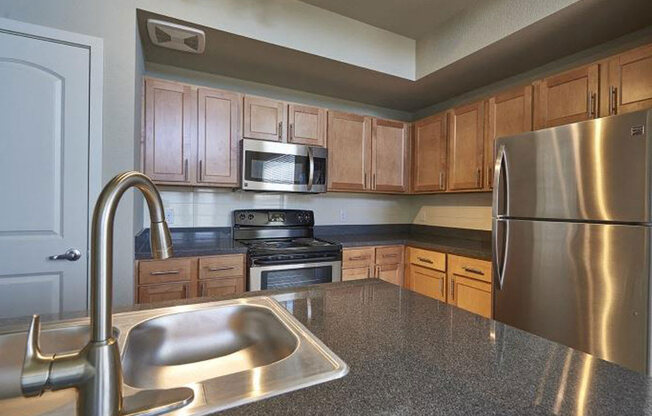 a kitchen with stainless steel appliances and a sink at Ridge at Thornton Station Apartments, Thornton, CO 80229