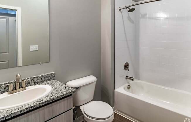 A white toilet sits next to a sink in a bathroom.