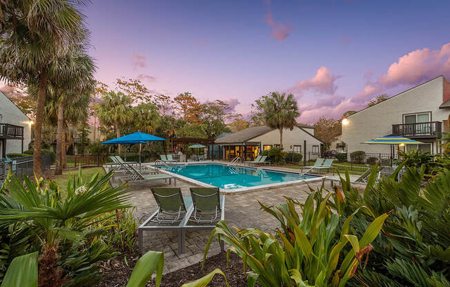 Community Swimming Pool with Pool Furniture at Heron Walk Apartments in Jacksonville, FL.