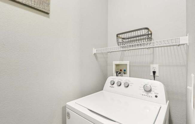 A white washing machine with a basket on top of it.