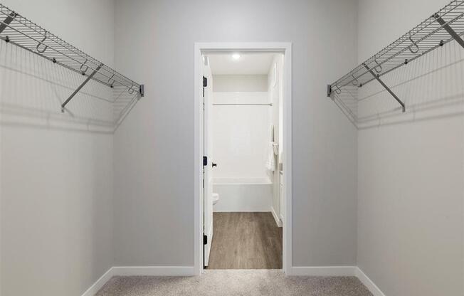 A white door is open to a hallway with a carpeted floor.