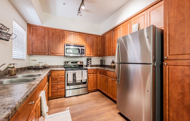 a kitchen with wood cabinets and stainless steel appliances