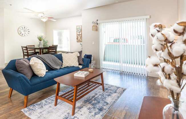 a living room with a blue couch and a wooden coffee table