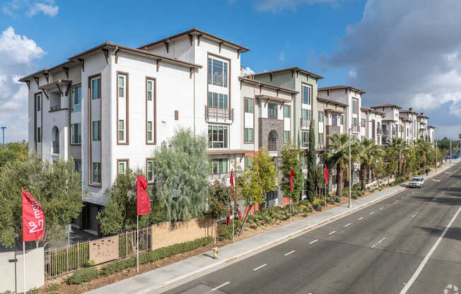 A row of modern townhouses with a street in front.