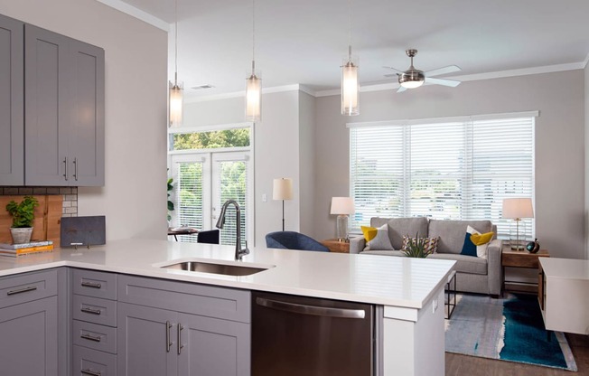 a kitchen with an island and a living room with a couch at One Riverside Apartments, Tennessee, 37403