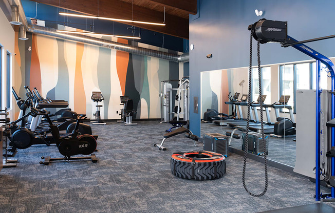 a gym with exercise equipment and a tire on the floor