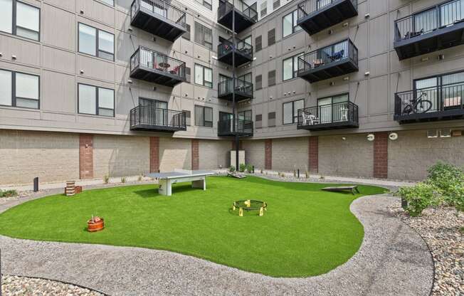 an apartment yard with a picnic table and a fire pit