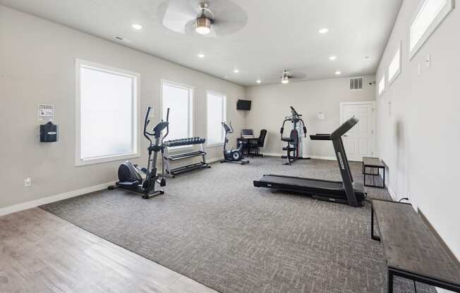 A spacious room with a treadmill, elliptical machines, and a stationary bike.
