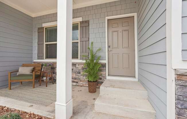 A house with a grey front porch and a white door.