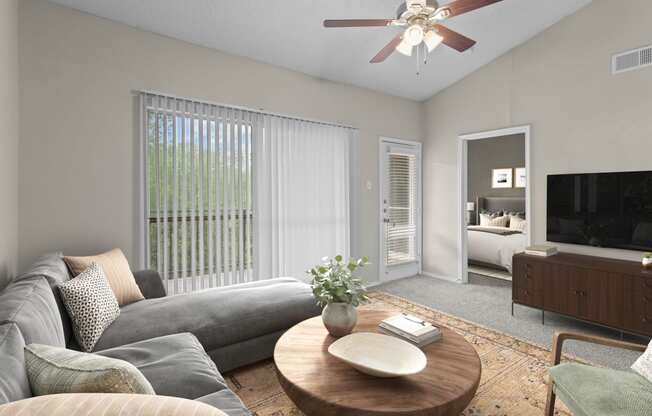 a living room with a couch and a coffee table and a ceiling fan