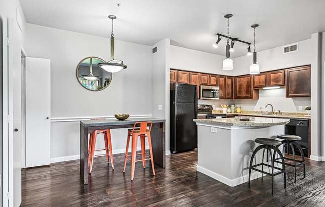 A kitchen with a table and chairs and a fridge.