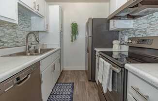 A kitchen with a black refrigerator and a white oven.