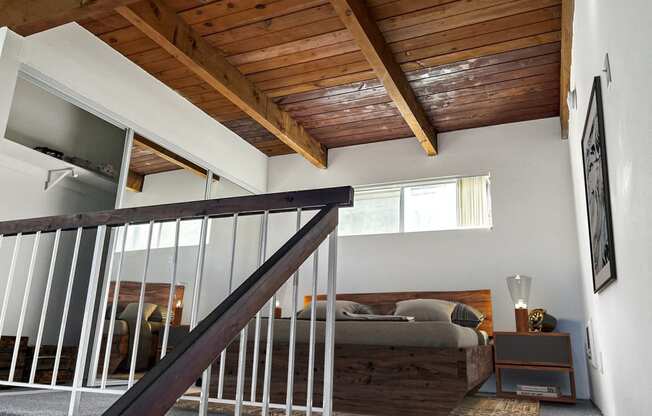 a lofted bedroom with a bed and a wooden ceiling