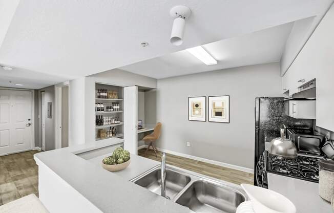 an open kitchen and living room with a sink and a refrigerator