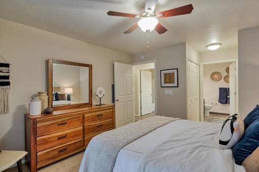 A bedroom with a bed, dresser, and mirror.