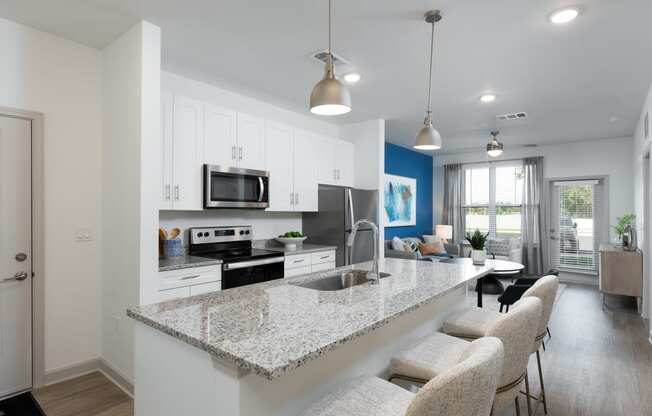 an open kitchen and living room with a granite counter top