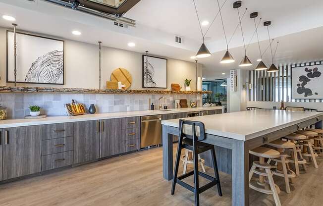 a large kitchen with a long counter and chairs