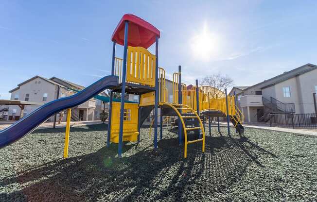 a playground with a swing set and slides in a yard