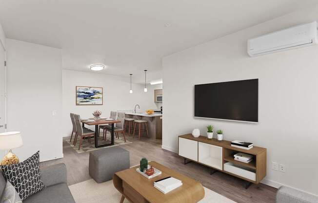 A living room with a grey couch, a wooden coffee table, a dining table with chairs, a flat screen TV, and a cabinet with shelves.