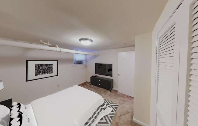 bedroom with bed, plush carpeting, dresser and tv at 1818 riggs apartments washington dc