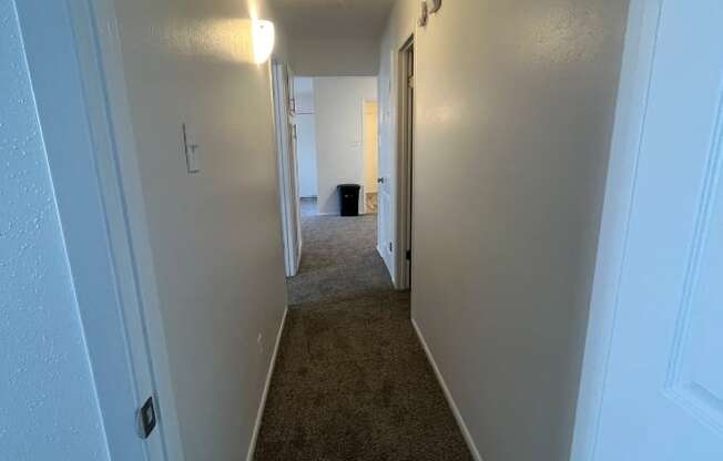 a hallway with a carpeted floor and white walls