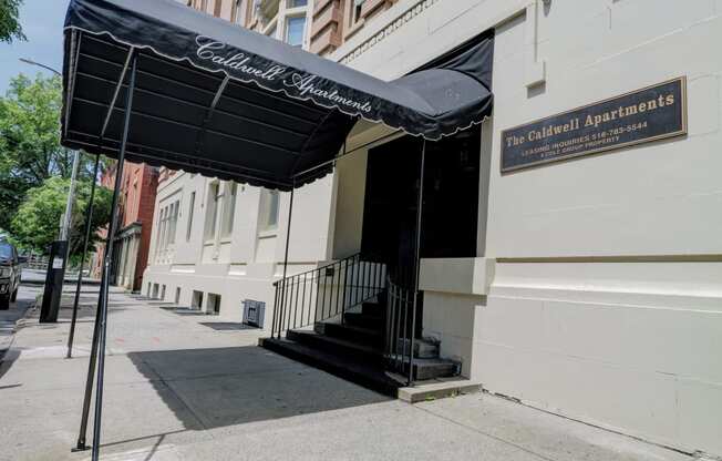 a building with a black awning on a sidewalk