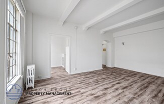 a living room with white walls and a wood floor