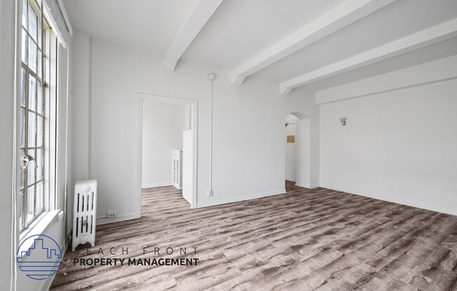 a living room with white walls and a wood floor