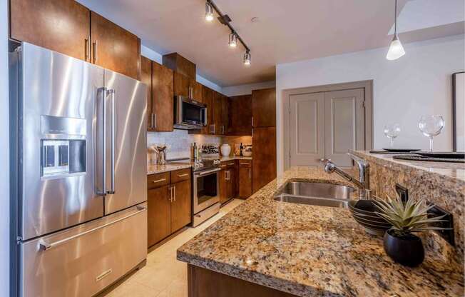 A kitchen with granite countertops and stainless steel appliances.