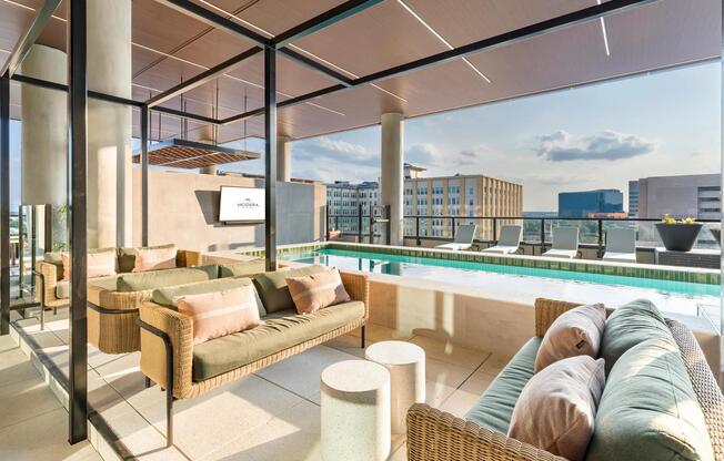 Relax in shaded poolside lounges at Modera St. Paul, where comfort meets stunning Dallas views for the perfect outdoor retreat.