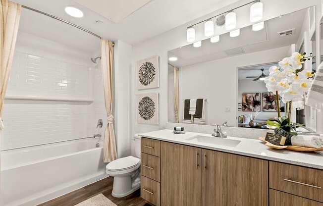 A bathroom with a white tub, sink, and toilet.