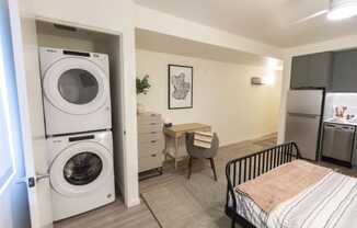 a washer and dryer in a living room with a desk and a kitchen at Moraine, Washington 98402