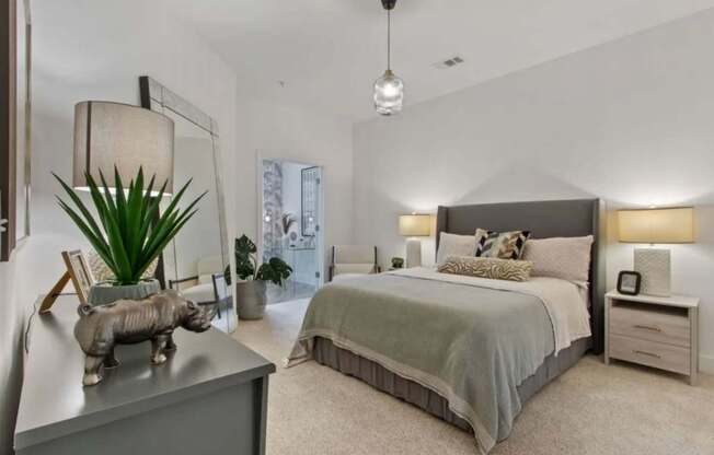 A bedroom with a large bed and a piggy bank on the dresser.