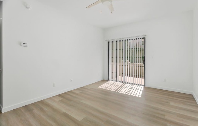 A room with a sliding door and a ceiling fan.