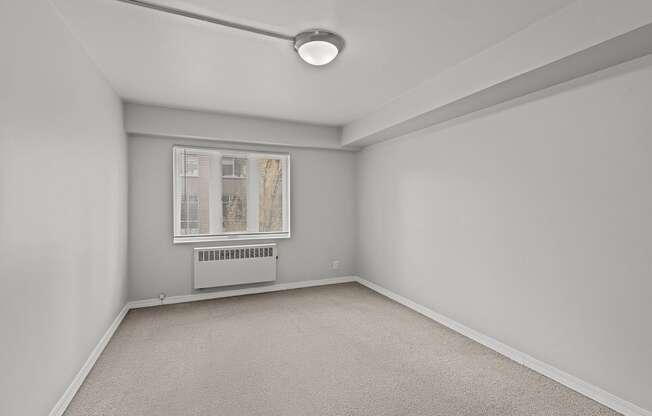 A room with a window and a carpeted floor