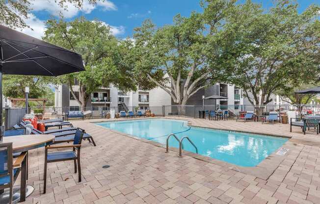 A pool surrounded by chairs and umbrellas.
