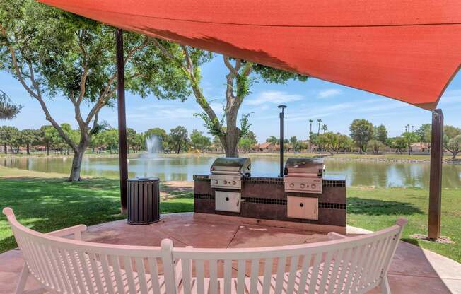 A white chair is in front of a table with a red canopy.