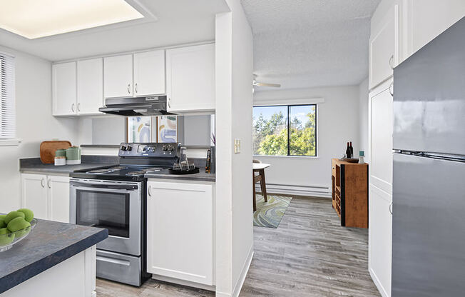 a kitchen with white cabinets and stainless steel appliances