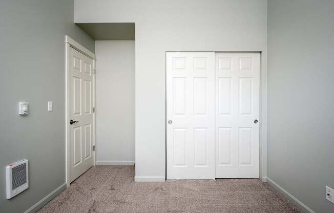 A room with two white doors and a carpeted floor.