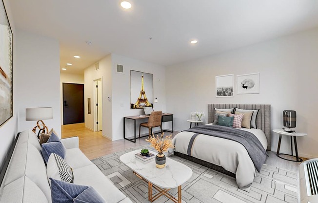 A modern bedroom with a large bed and a couch.