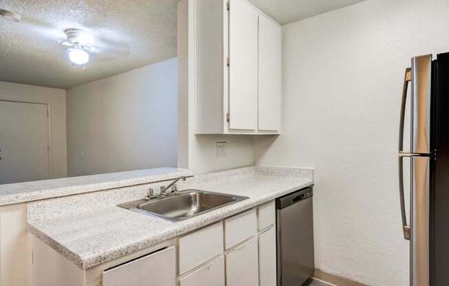 A kitchen with white cabinets and a granite countertop.