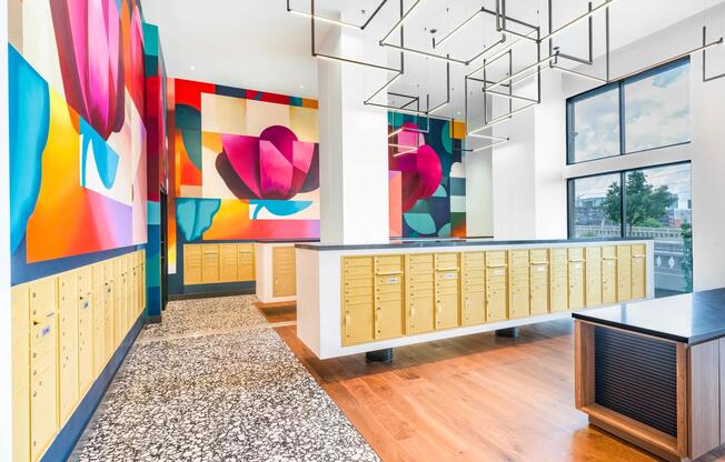Colorful wall murals and bold geometric lighting elevate the mailroom with modern Nashville flair.