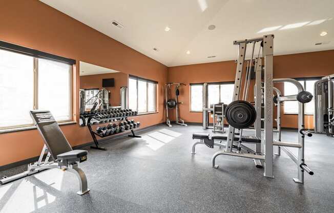 Fitness center with free weights, weightlifting machines and cardio equipment at at 360 at Jordan West best new apartments West Des Moines IA 50266
