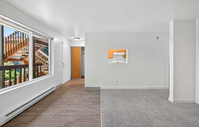 A room with a grey carpet and a wooden door.
