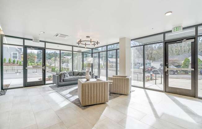 a living room with a couch and a coffee table in front of a wall of glass doors