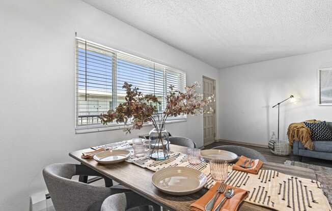 a dining room with a table and chairs and a window