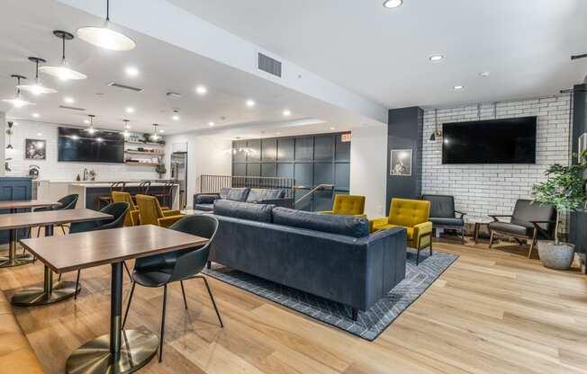 a living room with couches tables and chairs and a tv at The Commonwealth Building, Pittsburgh, 15222