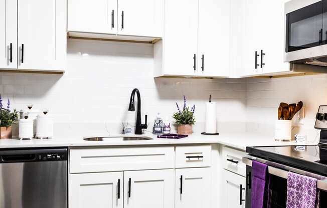 a kitchen with white cabinets and stainless steel appliances