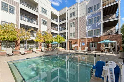 A swimming pool in front of apartment buildings.