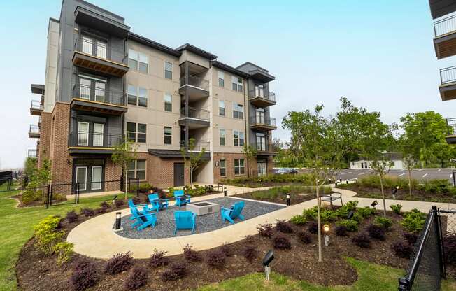 an outdoor patio with blue chairs in front of an apartment building
